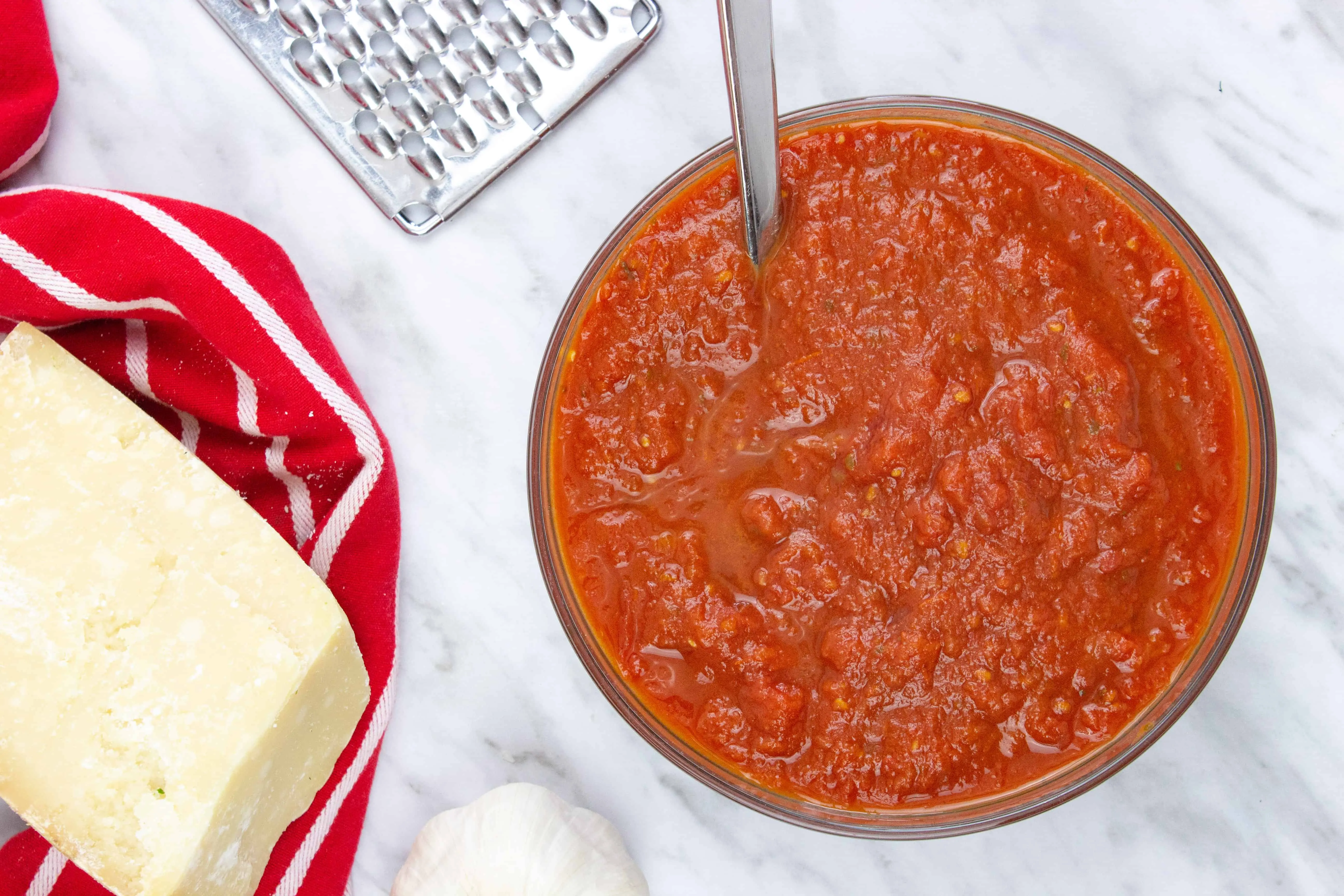 oven roasted tomato sauce in a bowl with parmesan nearby