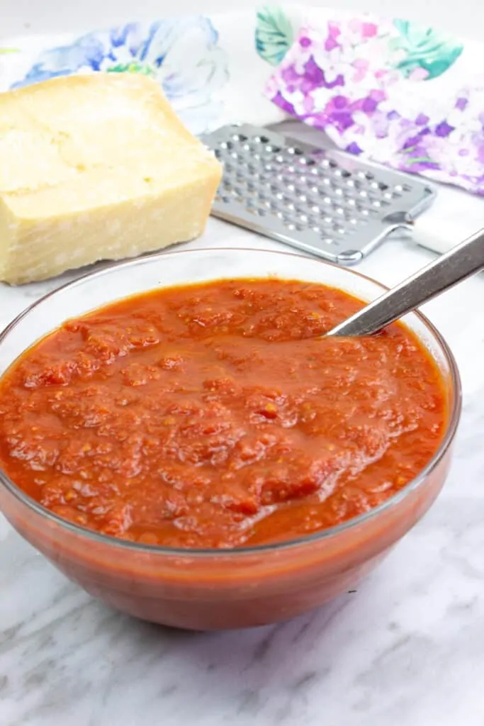 oven roasted tomato sauce in a bowl with parmesan in background