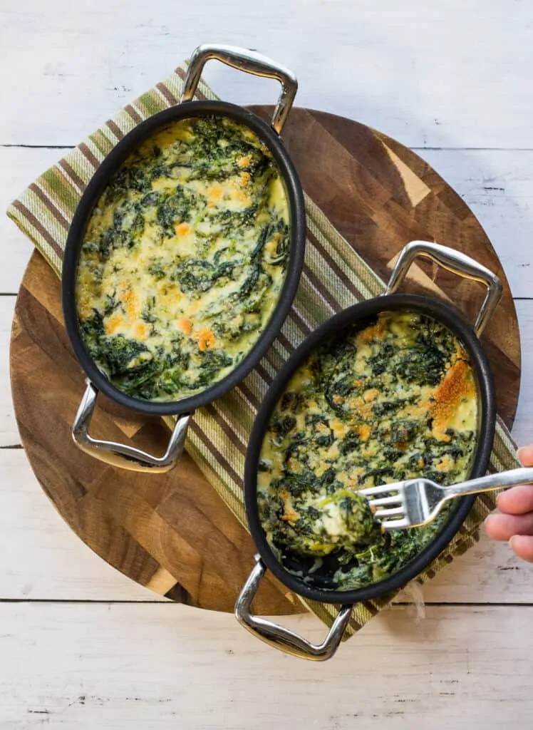 two servings of steakhouse creamed spinach in two dishes