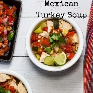 Mexican Turkey Soup in a white bowl next to a side of dish of pico de gallo.
