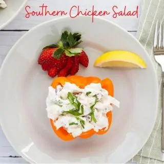 southern chicken salad in an orange bell pepper cup with a strawberry and lemon wedge on the side