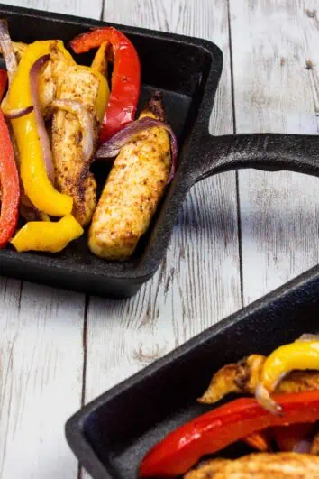 two portions of air fryer fajitas on square cast iron plates