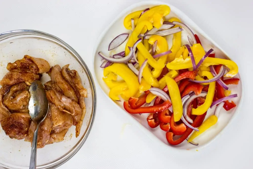 chicken tossed with seasoning and veggies cut ready to go