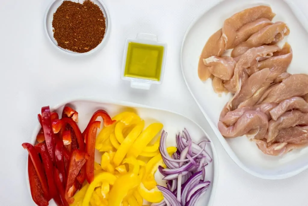 sliced onions and peppers, slicked chicken, seasoning and oil to make air fryer fajtias