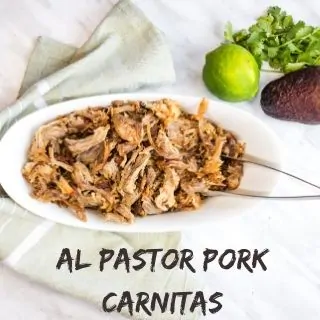 Al Pastor Pork Carnitas served in a bowl with a lime, cilantro, and avocado nearby.