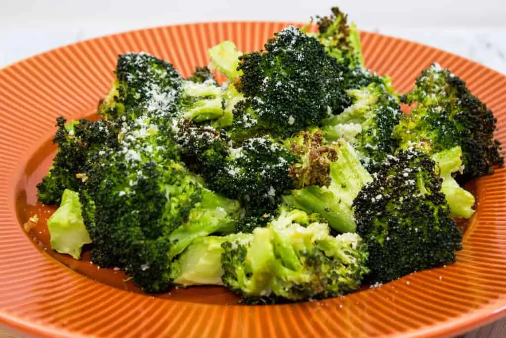 keto broccoli with parmesan and garlic on an orange plate
