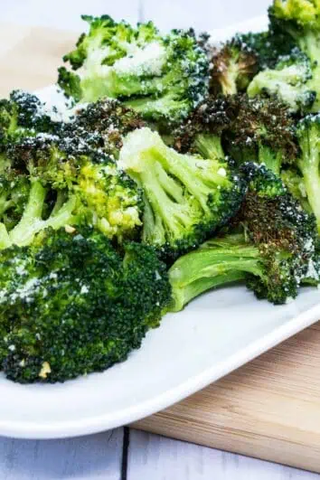 keto broccoli with garlic and parmesan on a white rectangular plate