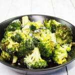 keto broccoli with garlic and parmesan on a black plate
