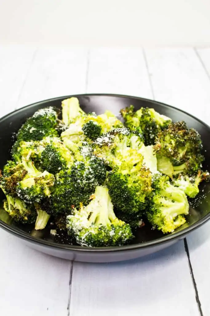 keto broccoli with garlic and parmesan on a black plate