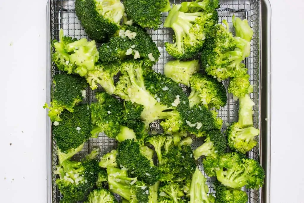 load the seasoned broccoli into an air fryer basket and cook