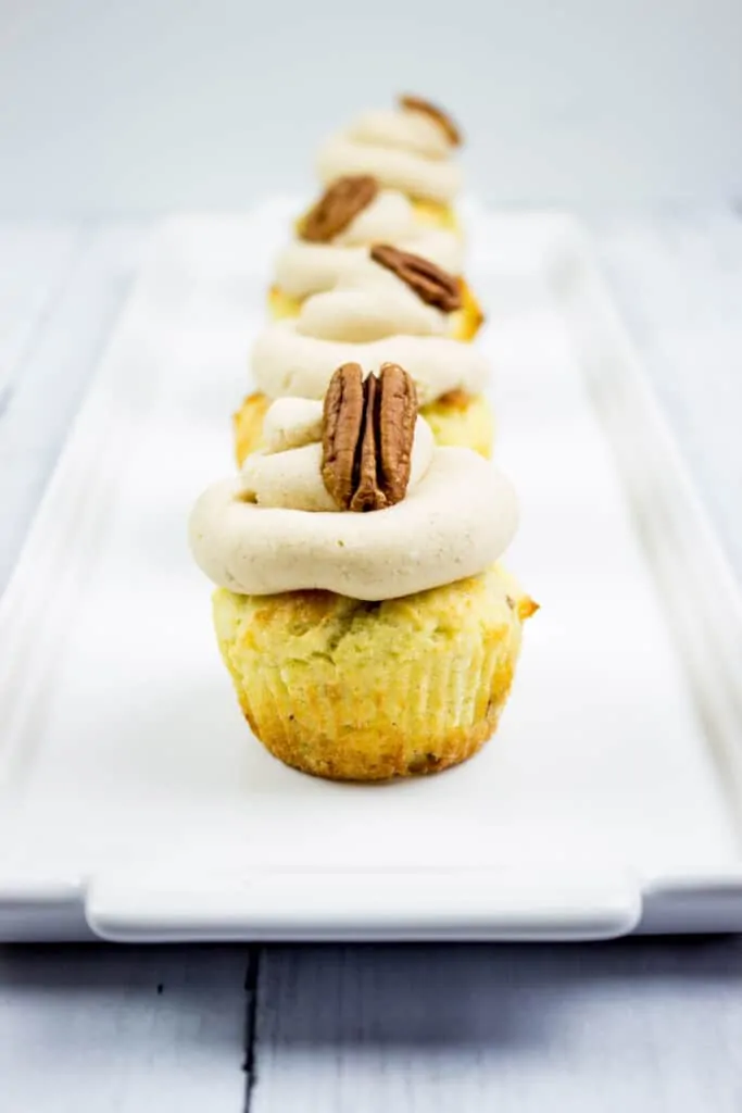 pecan cupcakes with brown butter cream cheese icing on a plate