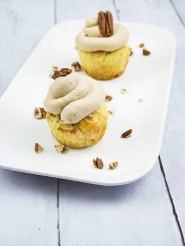 pecan cupcakes with brown butter cream cheese icing on a plate