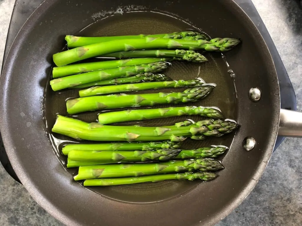 asparagus in a skillet with a wee bit of water