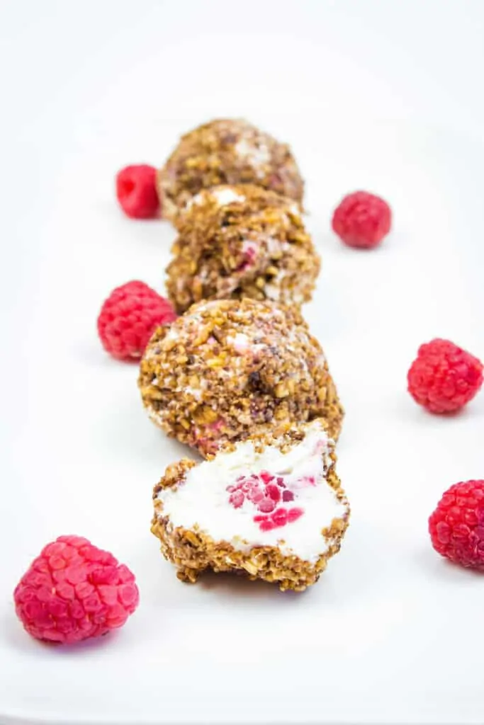 frozen cheesecake balls with raspberries in a dish