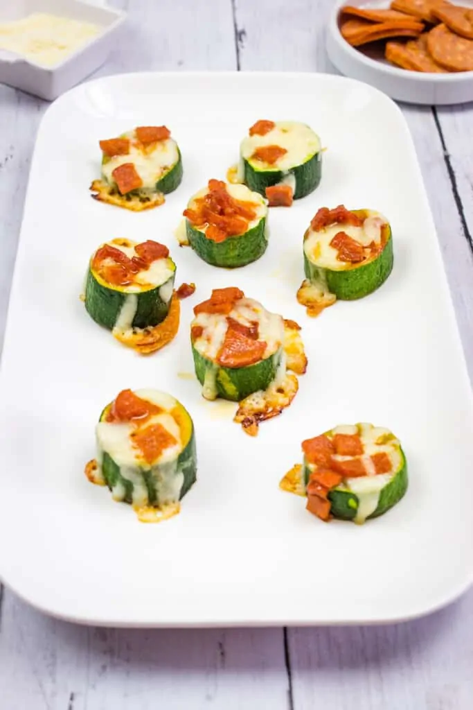 zucchini pizza bites on a rectangular white platter