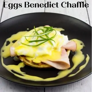 eggs benedict chaffle on a black oval plate