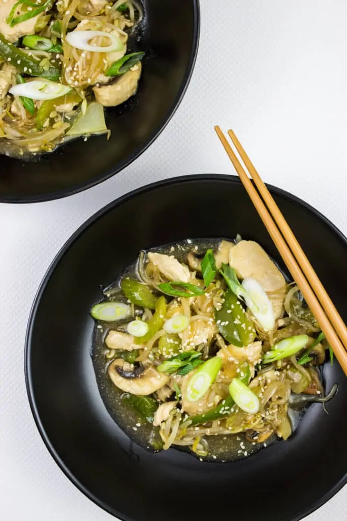 keto chicken stir fry in two black bowls with chopsticks