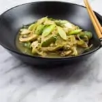 keto chicken stir fry in a black bowl with chopsticks on the side