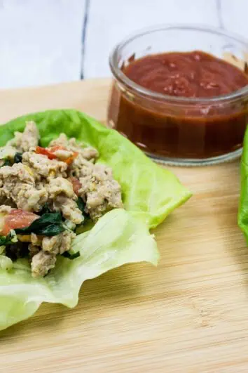 italian style keto ground chicken wraps on a board with sauce