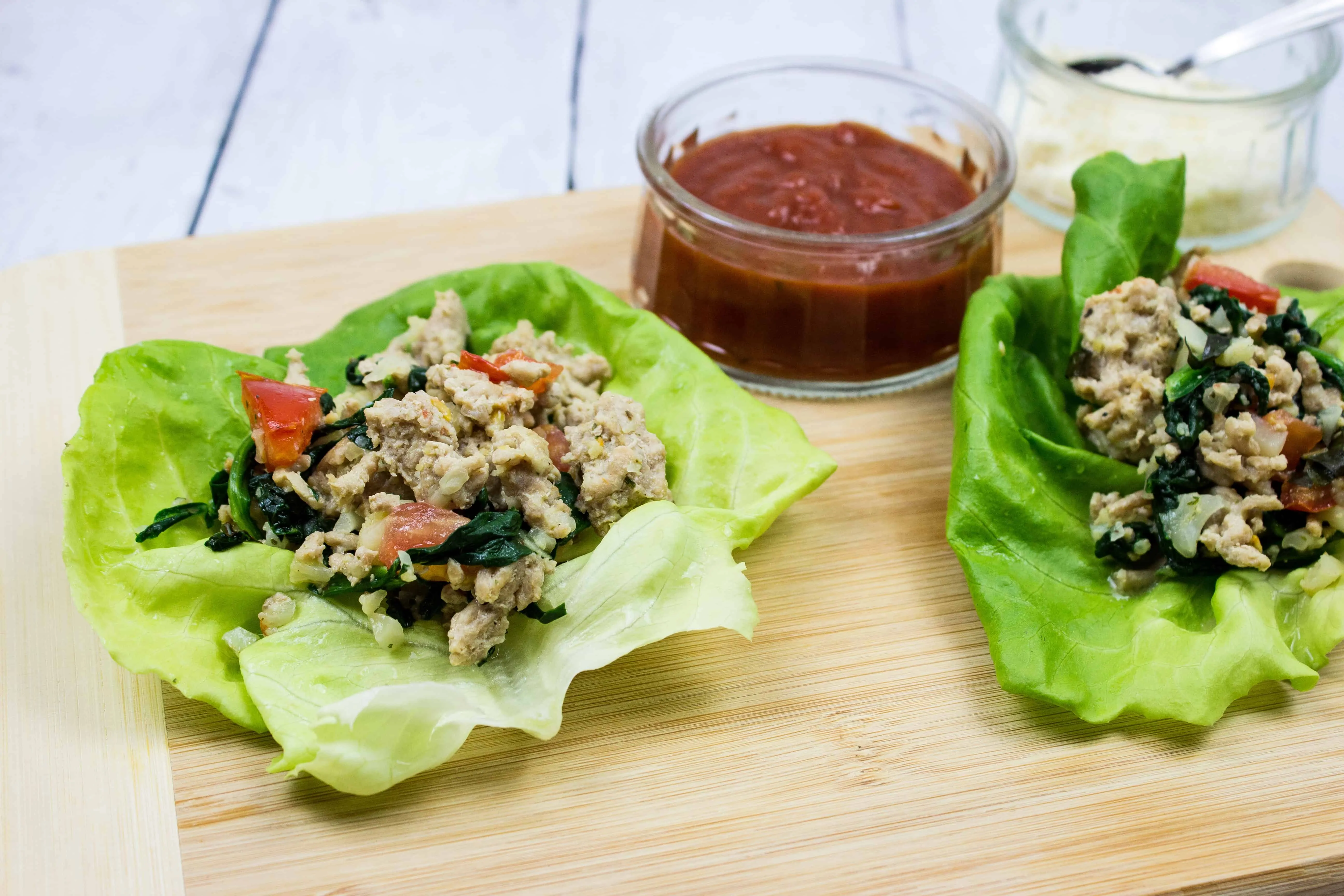 italian style keto ground chicken wraps on a board with sauce