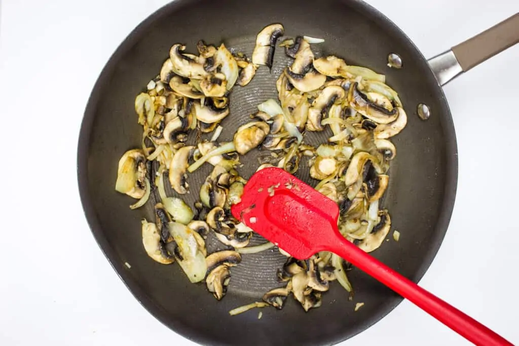 sautee the onions and mushrooms to make philly cheesesteak stuffed peppers