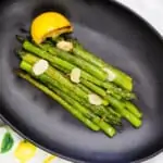 keto pan roasted asparagus with lemon on a black plate