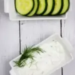 tzatziki sauce keto in a dish with sliced cucumbers on the side