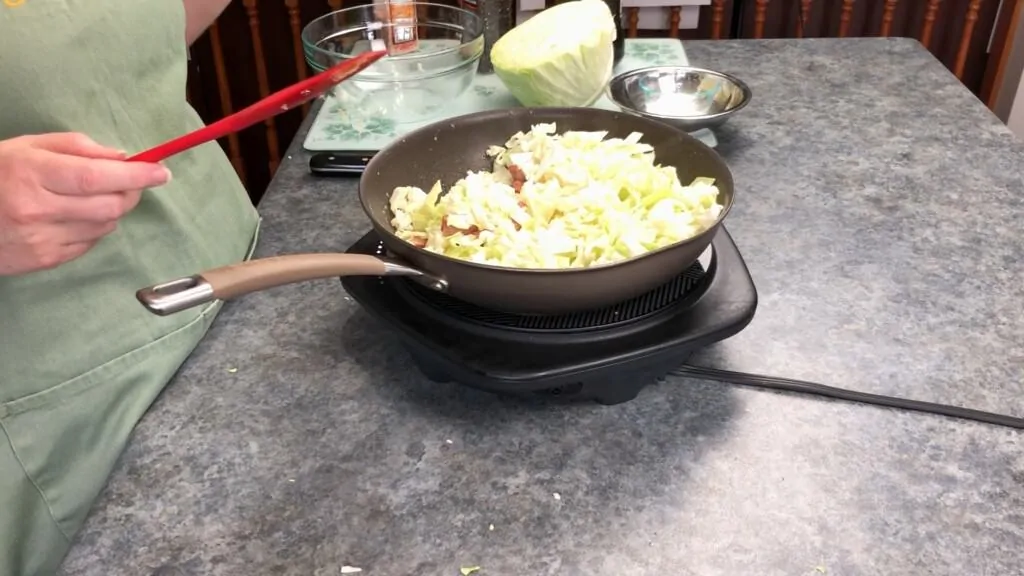 Add the cabbage to the pan with the sausage
