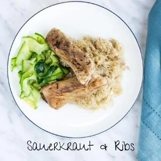 ribs and sauerkraut on a round plate with zucchini ribbons