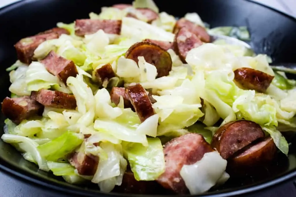 skillet cabbage and sausage in a black serving bowl