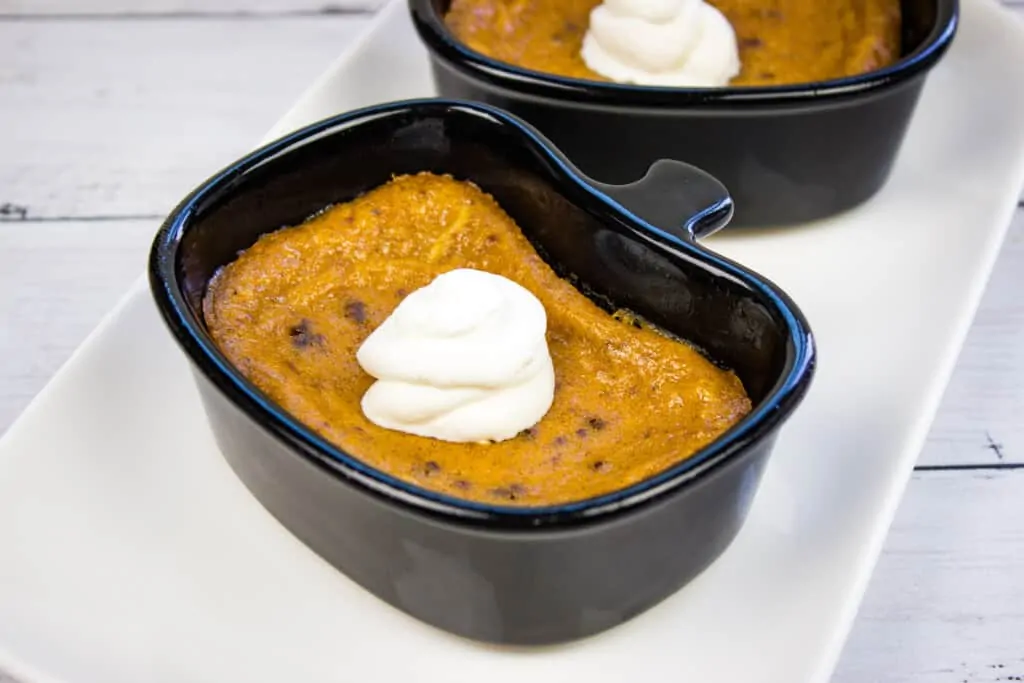 keto pumpkin custard in a black ramekin with a dollop of whipped cream