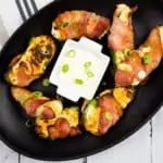 ranch keto jalapeno poppers on a black oval plate with sauce