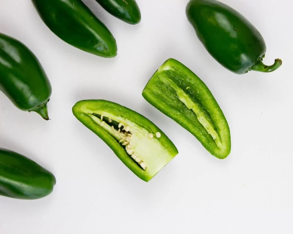 cut jalapenos in half with sharp knife