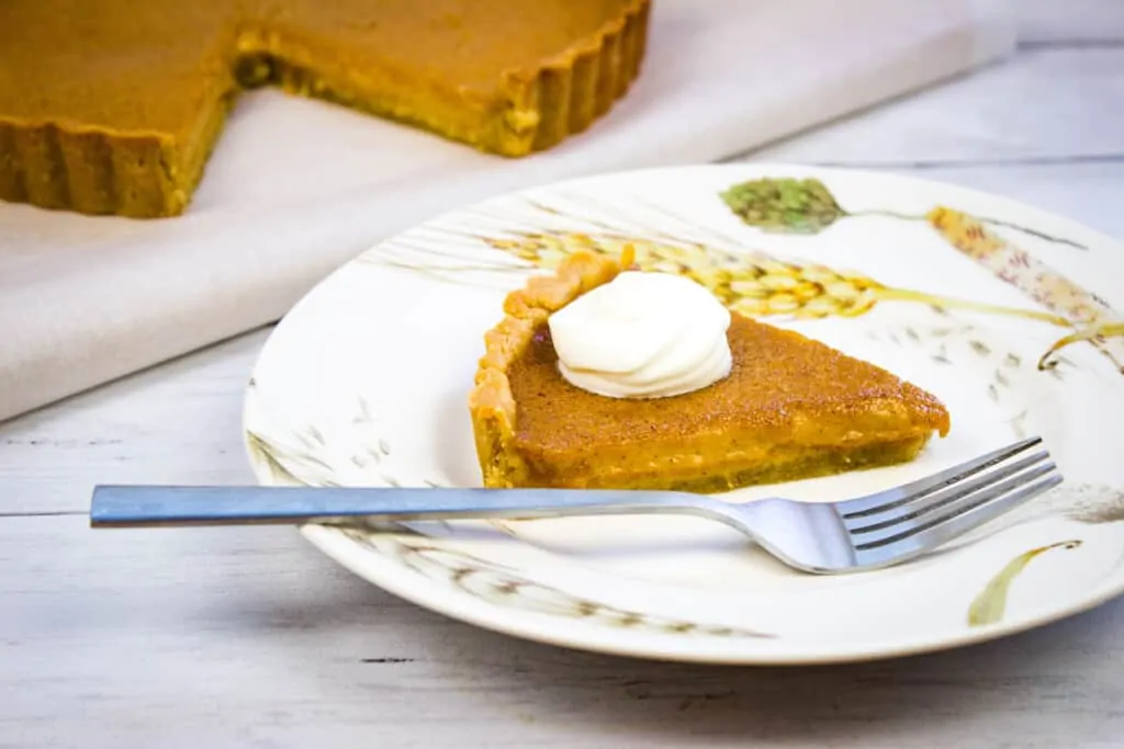 keto pumpkin pie on a plate with whipped cream