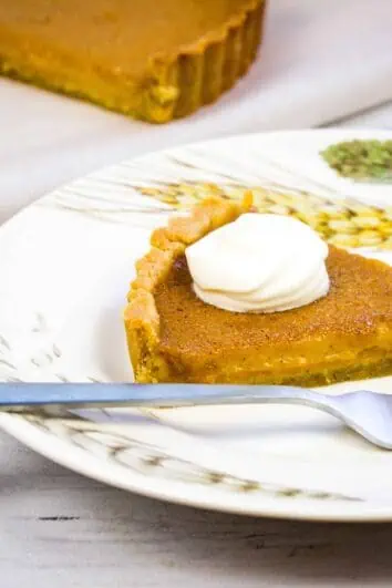 keto pumpkin pie on a plate with whipped cream