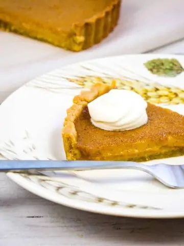 keto pumpkin pie on a plate with whipped cream