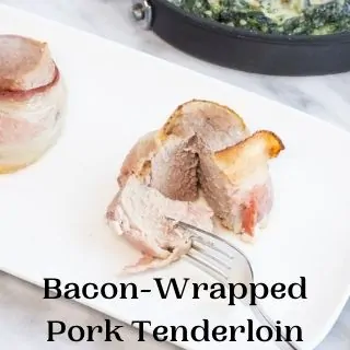 keto bacon wrapped pork tenderloin on a plate with spinach