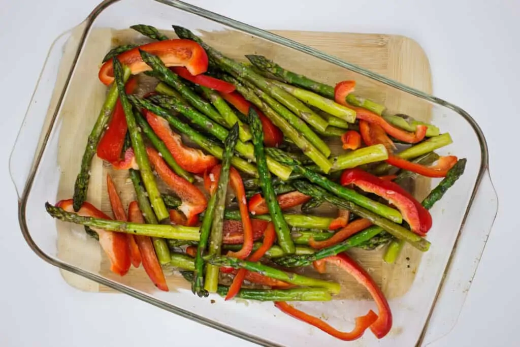 adding peppers to the roasted asparagus