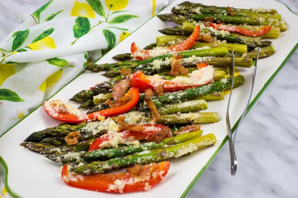 keto cheesy baked asparagus with bacon and bell peppers on a platter