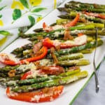 keto cheesy baked asparagus with bacon and bell peppers on a platter