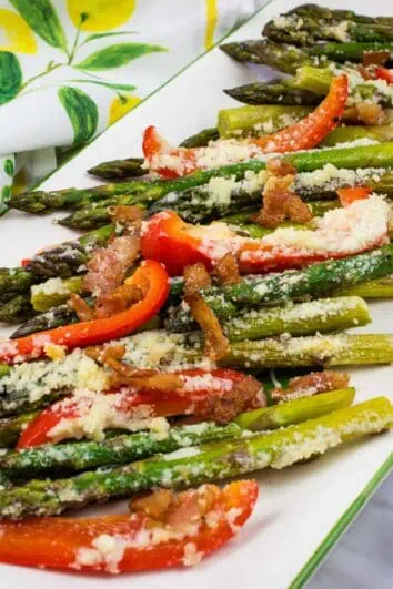 keto cheesy baked asparagus with bacon and bell peppers on a platter