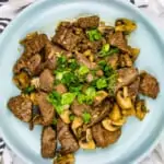 keto garlic steak with mushrooms on a round plate