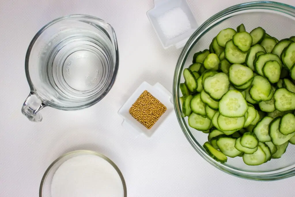 sliced cucumbers and other ingredients to make keto pickles