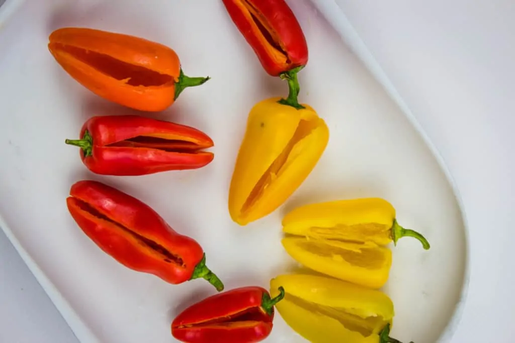 sweet peppers with a slit cut into them and seeds removed