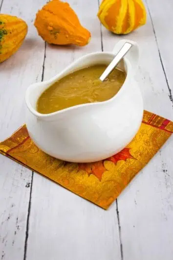 Keto Turkey Gravy in a gravy boat with gourds in the background