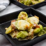 keto parmesan brussels sprouts with bacon in a black cast iron serving dish