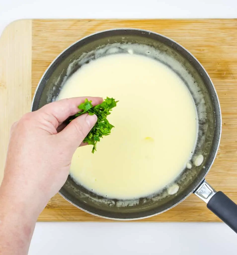 adding chopped parsley to the sauce