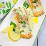 salmon with lemon-herb butter sauce on a platter