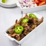 keto beef barbacoa recipe with tortillas in background