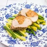 keto stuffed pork tenderloin on a plate with beans